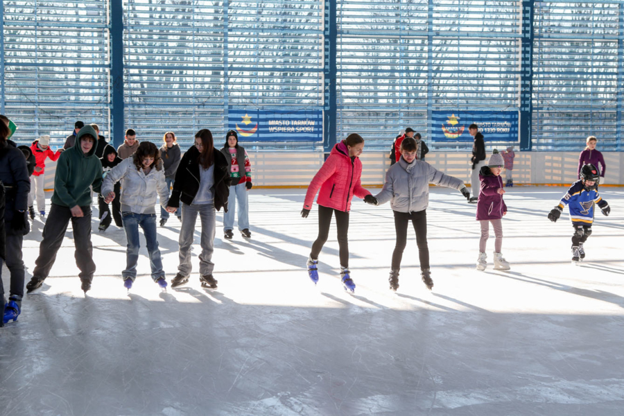 na zdjęciu osoby jeżdżące na lodowisku