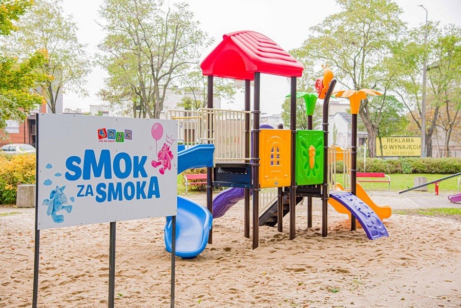Na zdjęciu kolorowy plac zabaw oraz napis Smok za Smoka